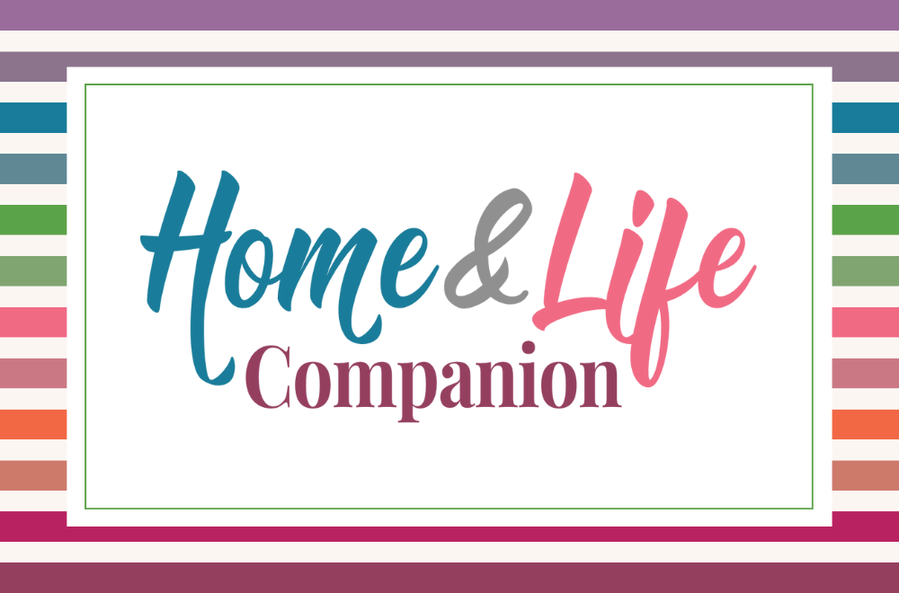 This image has a reverse rainbow striped background. On top of the background is a white rectangle with a green border inset from the edges. Then in colourful fonts the words Home and Life Companion are centred on the white box.