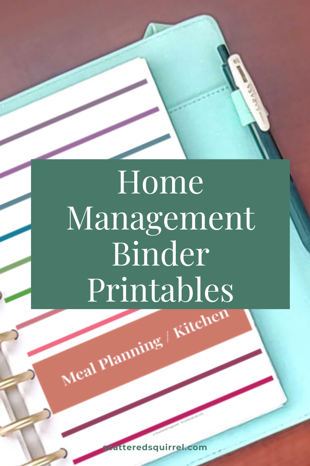 Teal planner binder open to a color-coded tab page with a "Meal Planning / Kitchen" section visible, pen tucked into the cover pocket